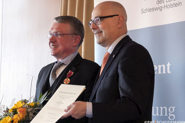  – Michael Frömter nimmt die Auszeichnung von Ministerpräsident Torsten Albig (SPD, re.) entgegen. Foto: Pat Scheidemann